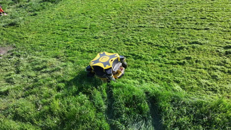 Drone-Shot-of-Remotely-Controlled-Modern-Lawn-Mower-in-Green-Grassland-on-Sunny-Day