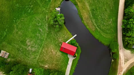 Diese-Fantastischen-Drohnenaufnahmen-Zeigen-Einen-Atemberaubenden-Blick-Auf-Einen-Ruhigen-See-Auf-Einem-Bauernhof,-Umgeben-Von-Leuchtendem-Grün