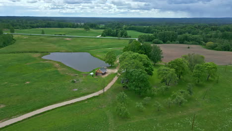 The-gorgeous-drone-shot-brings-out-the-true-beauty-of-this-lush-farmland-landscape-with-a-pond,-which-is-really-a-sight-for-sore-eyes