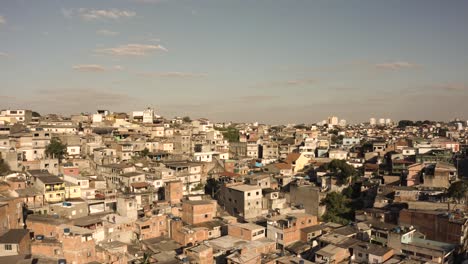 Aerial-establishing-drone-shot-of-sun-lighting-on-Favela-houses-in-Sao-Paulo-during-sunset-time,-Brazil