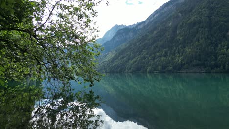 Mirror-like-surface-of-Klontalersee-lake-reflecting-Alpine-mountains,forests