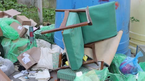 Old,-broken-chair-on-pile-of-garbage-ready-for-removal-and-disposal-in-Romania