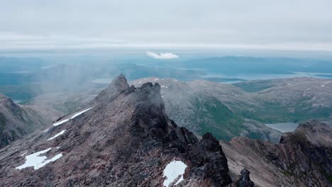 Pinnacle-Peaks-Of-Majestic-Kvaenan-Mountain-In-Fog-Near-Senja-Island-In-Norway