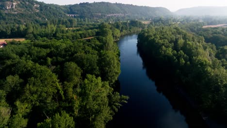 Aerial-shot-over-a-wild-river-in-the-Lot,-the-valley-is-beautiful-with-morning-mist,-Dordogne,-France
