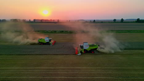 Combine-harvesters-gather-wheat-crops-at-sunset---aerial