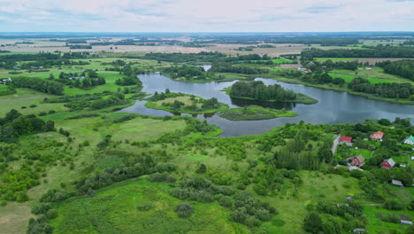 Aerial-of-vast-lake-adorned-with-forested-islands-in-Aizpute,-Latvia