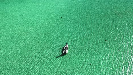 High-Aerial-View-of-Fishing-Boat,-Turquoise-Water,-and-Ripples,-Bahamas