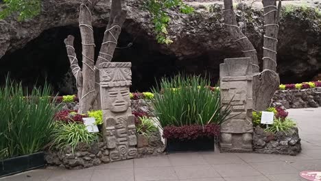 Absteigende-Aufnahme-Von-Totempfählen-Als-Dekoration-In-Einem-Botanischen-Garten-In-Mexiko