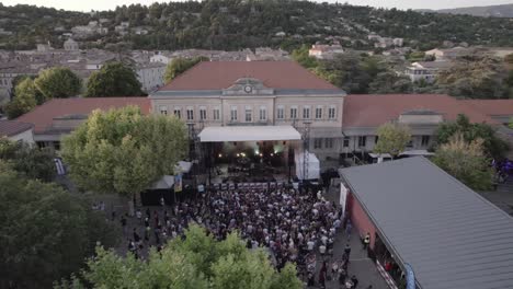 Un-Dron-Captura-El-Escenario-De-Un-Concierto-De-Rock-Con-Luces-Intermitentes-Y-Una-Audiencia-Enérgica