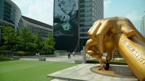 Tourist-People-Taking-Picture-With-Gangnam-Style-Statue-In-Front-Of-COEX-Mall-In-Seoul,-South-Korea
