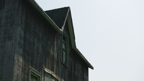 Der-Wind-Bläst-Das-Zerbrochene-Fenster-Eines-Unheimlichen,-Verlassenen,-Verbrannten,-Dunklen-Holzgebäudes-Auf