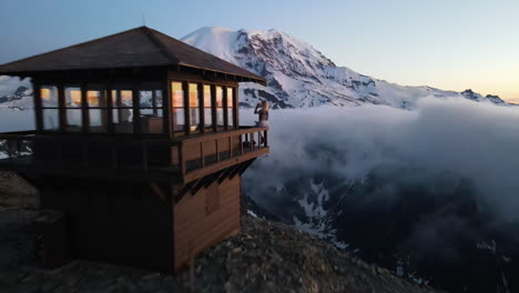 Schönes-Blondes-Mädchen-Mit-Einem-Lächeln-Im-Gesicht,-Das-Auf-Dem-Mount-Fremont-Fire-Lookout-Steht-Und-Den-Mount-Rainier-Bei-Sonnenuntergang-Beobachtet