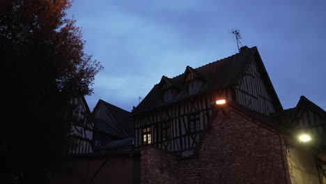 Blue-hour-glow-in-sky-at-dusk-above-old-classic-french-buildings-in-countryside