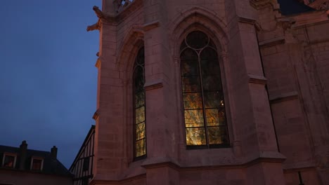 Warm-red-glow-from-inside-cathedral-chapel-illuminates-windows-of-church-at-blue-hour
