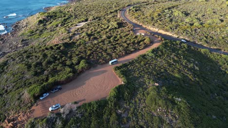 Aerial-shot-of-tourist-bus-leaving-parking-area-at-Gracetown-Beach-during-sunny-day-in-Margaret-River,Australia