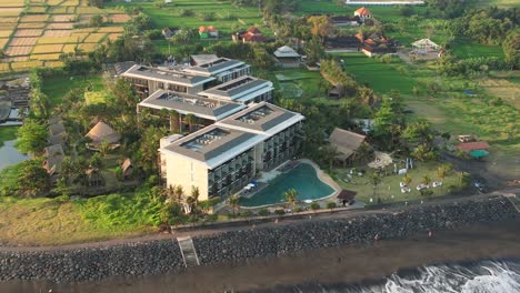 Luxury-Wyndham-Tamansari-Jivva-Resort-Bali-Under-Sunset-Sunlight-Surrounded-with-Farmlands-and-Rice-Fields-in-Semarapura,-Indonesia---Aerial-Parallax