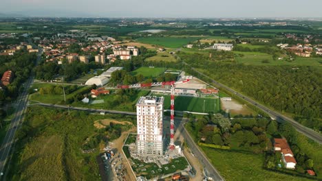 Flying-over-crane-for-construction-of-residential-Torre-del-Verde-skyscraper-in-Vimercate,-Brianza-in-Italy