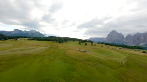 FPV-drone-flying-in-the-plateau-of-Alpe-di-Siusi,-Seiser-Alm-meadows-at-sunrise-in-the-Dolomites-mountains,-Italian-Alps