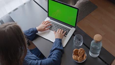 Junge-Frau-Tippt-Auf-Der-Tastatur-Eines-Laptops-Mit-Grünem-Bildschirm