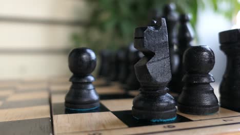 Schachspiel,-Schwarze-Figuren,-Frauenhand,-Die-Den-Ritter-Aus-Nächster-Nähe-Bewegt