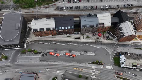 Public-bus-station,-railway-and-hotel-buildings-in-city-of-Voss-Norway---Aerial-top-down-view