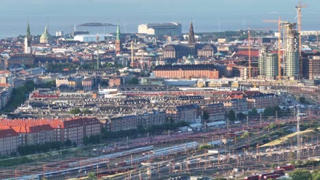 Beautiful-scenic-reveal-drone-cityscape-of-Copenhagen-from-railway-station,-commercial-zone-to-horizon