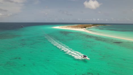 Speed-boat-races-across-clear-ocean-in-cayo-de-agua-los-roques,-aerial-tracking