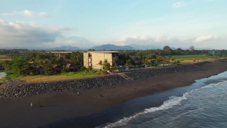 Luftaufnahme-Des-Wyndham-Tamansari-Jivva-Resort-Bali-Bei-Sonnenuntergang-Mit-Freizügiger-Poollounge-Und-Gebäudefassade-In-Tropischer-Landschaft-Auf-Bali,-Indonesien