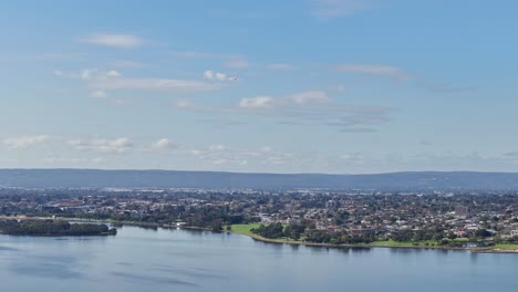Aerial-view-of-the-Perth-hills-with-plane-landing-into-the-airport-over-Swan-River