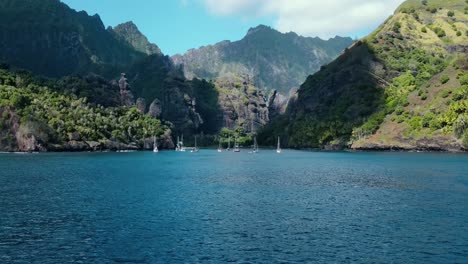 Distant-View-from-the-Sea-of-many-sailboats-in-the-Tropical-Bay-of-Virgins-Fatu-Hiva-Marquesas-Islands-French-Polynesia-South-Pacific-Ocean