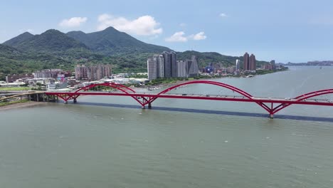 Guandu-Bridge,-iconic-arched-bridge-and-Taipei-cityscape