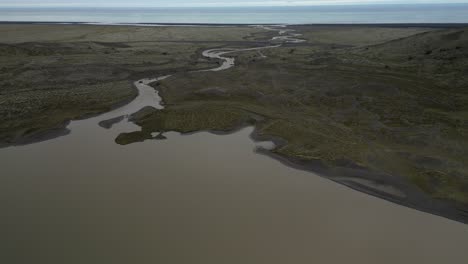 Muddy-glacier-river-streaming-into-Atlantic-ocean-across-the-valley