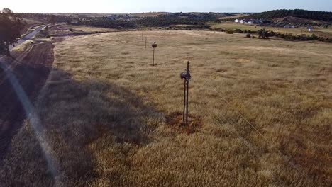 Slow-Motion-Aerial-View-of-Alentejo---Portugal:-Rustic-Elegance---Wheat-Fields-and-Stork-Nests-on-Tall-Poles