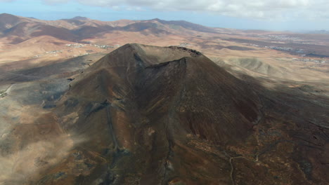 Caldera-Volcánica-Gairia:-Toma-Aérea-En-Un-Círculo-Del-Cráter-De-La-Caldera-Volcánica-En-Un-Día-Soleado-Y-Con-Reflejos-De-Las-Nubes-En-La-Caldera