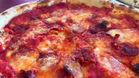 Delicious-traditional-Italian-pizzas,-pepperoni-pizza-and-mortadella-pizza-with-pistachios-and-burrata-mozzarella-cheese,-4K-shot