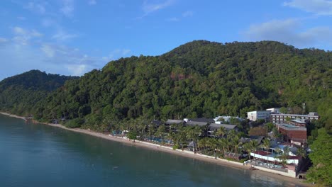 Amazing-aerial-top-view-flight-Beach-Village-Huts-Resort,-tropical-Bungalows-on-Mountainous-Island-Thailand-2022