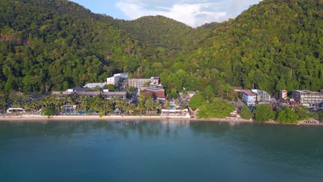 Magic-aerial-top-view-flight-Beach-Village-Huts-Resort,-tropical-Bungalows-on-Mountainous-Island-Thailand-2022