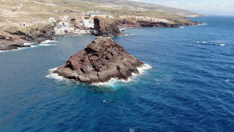 Roques-de-Fasnia,-Tenerife:-aerial-view-traveling-out-to-the-rock-formations-of-Fasnia,-on-the-coast-of-Santa-Cruz-de-Tenerife,-on-a-sunny-day