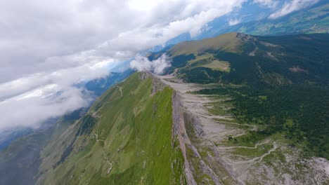 FPV-drone-flying-from-the-clouds-in-Seceda-mountain-ridge-located-in-Dolomite-Mountains,-Italian-Alps