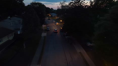 Car-driving-through-small-town-community-at-night