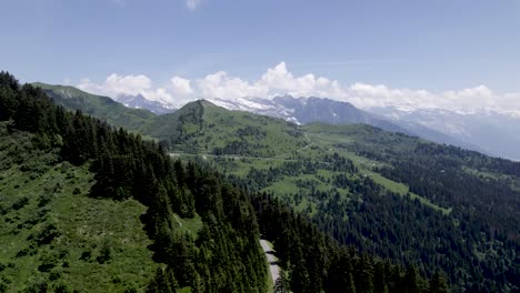Rückwärtsbewegung-Aus-Der-Luft-Mit-Blick-Auf-Die-Straße-In-Den-Bergen-Der-Französischen-Alpen-Mit-Den-Massiven-Und-Ewigen-Schneegipfeln-Des-Mont-Blanc-Im-Hintergrund
