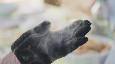 Ball-of-dry-ice-evaporates-in-a-hand-wearing-a-black-protective-glove