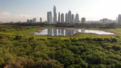 An-aerial-view-of-the-Buenos-Aires-City-with-ecological-reserve-wetland,-with-the-city-skyline-in-the-reflection