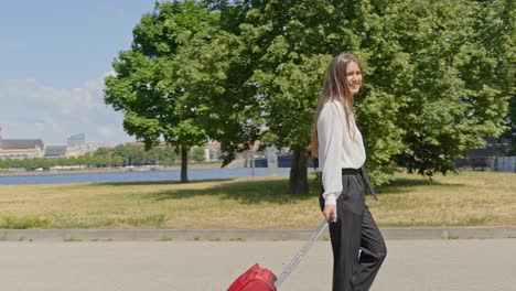 Happy-businesswoman-arrived-to-Riga-city,-walking-with-luggage