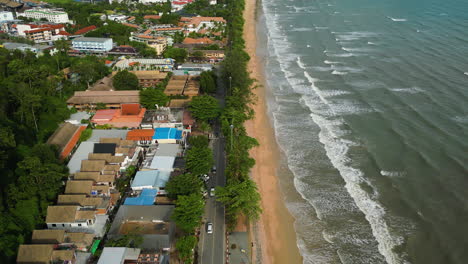 Main-central-beach-in-Ao-Nang-thailand-with-traffic-on-beachside-street,-aerial