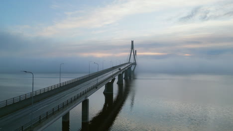 Establishing-aerial-shot-of-Replot-bridge-in-Finland-at-dawn,-car-passing-by