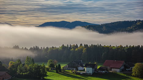 Rural-home-near-forest-and-mountains,-low-flowing-clouds,-time-lapse