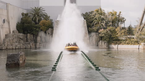 Tourists-in-masks-riding-Jurassic-Park:-The-Ride-at-Universal-Studios-Japan-in-Osaka-with-water-splashing-everywhere