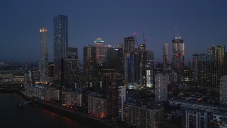Aerial-over-River-Thames-of-illuminated-Canary-Wharf-buildings-at-twilight