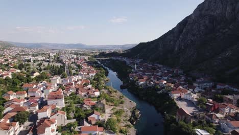 Aerial:-Mostar,-river-winding-through,-framed-by-mountains